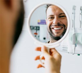 a man smiling after paying the cost of cosmetic dentistry