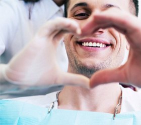 a patient making a heart sign with his dentist img-border