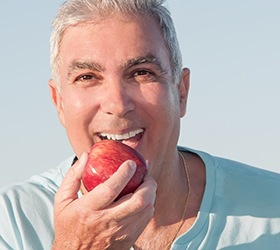 Older man biting an apple
