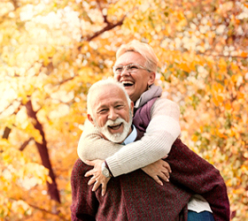 An older man and woman enjoying life and smiling