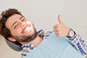 man thumbs up in dentist chair