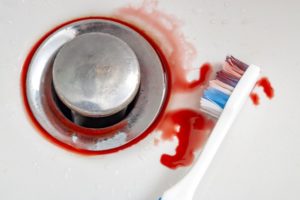 toothbrush in a sink with blood on it