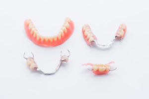 Set of full and partial dentures on white background