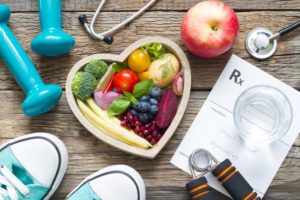 a bowl of heart-healthy foods surrounded by exercising gear to portray a person working to make their heart healthy