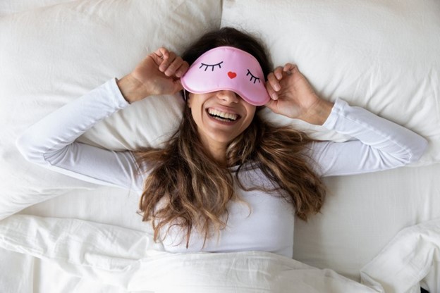 Woman sleeping in her bed during the summertime.