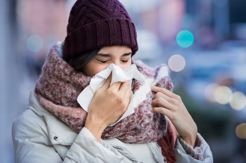 woman sneezing during cold and flu season in Bloomfield Hills