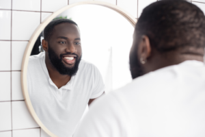 a person smiling and looking in the mirror