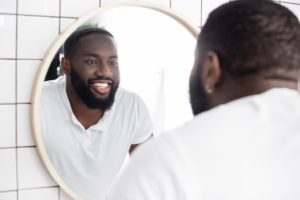 a person smiling and looking in the mirror 