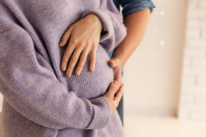 Woman resting her hands on her baby bump
